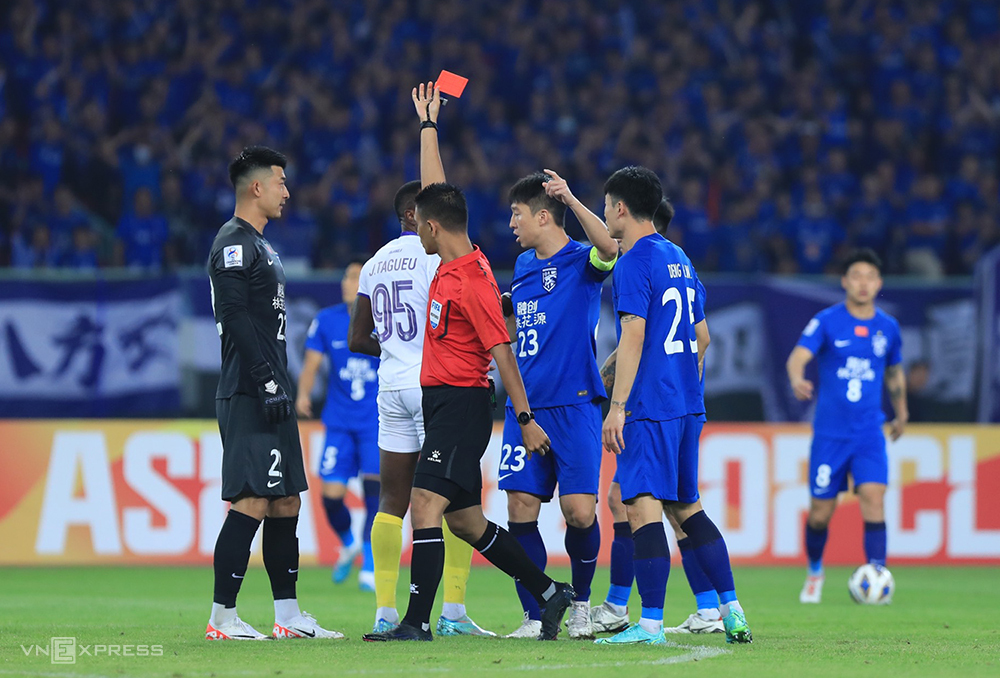 Trọng tài rút thẻ đỏ truất quyền thi đấu của Joel Tagueu trong trận Hà Nội FC thua 1-2 trên sân của Wuhan Three Towns ngày 24/10. Ảnh: Minh Dân